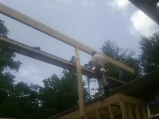 Carpenter setting a ridge beam over a new addition frame — Ice Dam Removal by Roofing Brothers in Zanesville